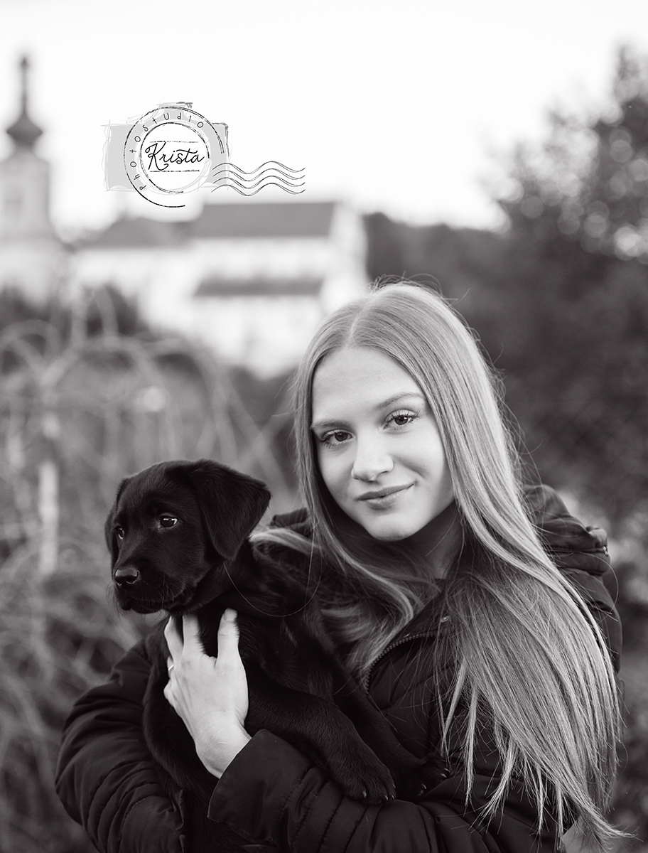 Dívka s černým štěnětem labradora — černobíle