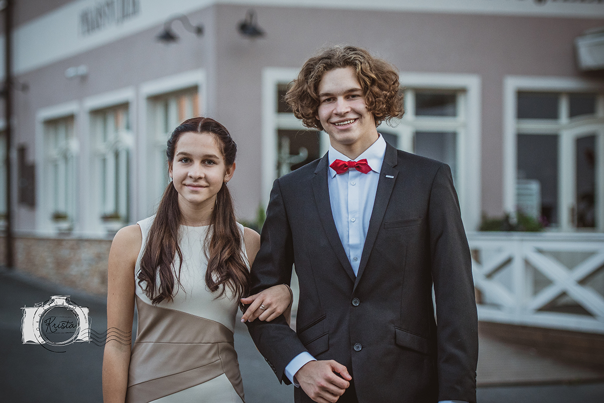 Maturantský pár — chlapec s motýlkem a dívka v béžových šatech